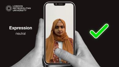 A photo of a student, on a cartoon phone, being held by someones hands with a green tick on the right.