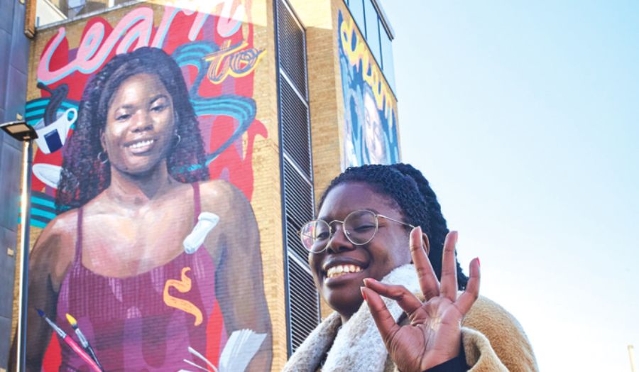Maria Epam in front of the 'Learn to Dream' mural