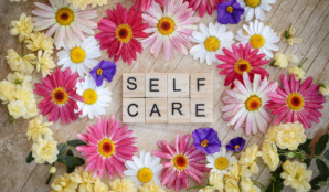 The words self-care surrounded by flowers