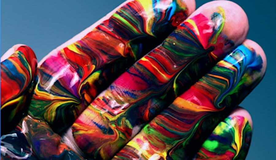 A hand covered in rainbow pain