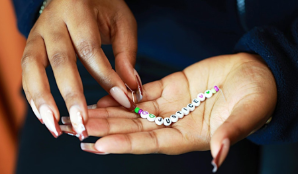 Hands holding a 'Justice' bracelet