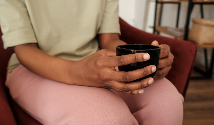Person sitting and holding a cup