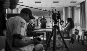 A black-and-white photo showing a film crew at work in a classroom at London Metropolitan University