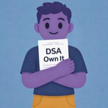 A person holding a piece of paper on which is written 'DSA Own It'.