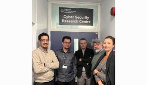 5 researchers who won the funding standing in front of the door to the Cybersecurity Research Centre