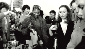 A black and white image of a group of women drinking and smiling