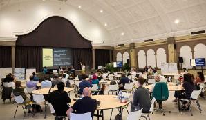 An audience listening to speakers in the Great Hall